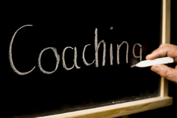 Coaching concept, inscription on the blackboard background