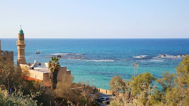 Yacht moving on Mediterranean sea behind minaret background