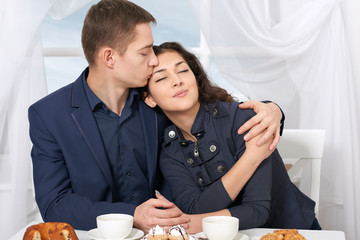 happy couple drinking coffee and resting near window with a sky view - travel and love concept