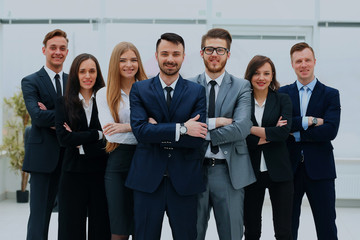Obraz premium Smiling and confident business team standing in front of a bright window.