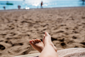 Feet of a child on a beach background.