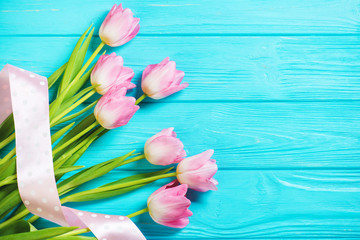 Wooden blue background and pink tulips