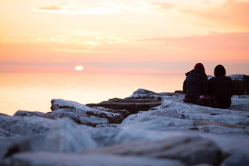 Naklejka na ściany i meble coppia di innamorati guarda il tramonto al mare