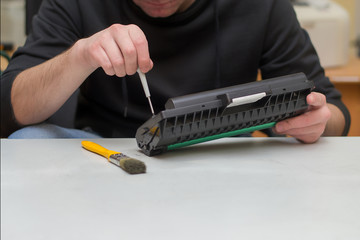 a specialist in the repair of printers refills and makes maintenance of the cartridge from a laser...