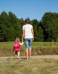 Fototapeta premium Flicka leder liten flicka hand i hand