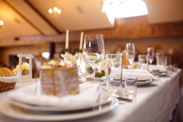 Beautiful table setting with crockery and flowers for a party, wedding reception or other festive event. Glassware and cutlery for catered event dinner.
