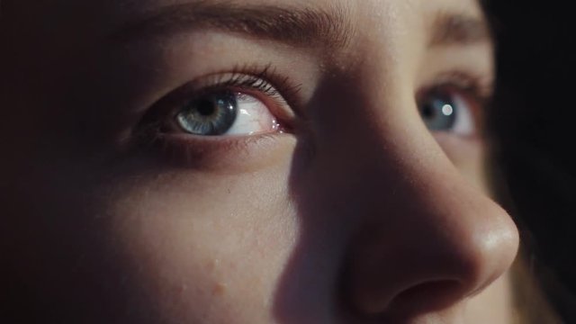 Extreme close up view of stunning blue-eyed woman opening her eyes, taking a deep breath and looking around. Slow motion