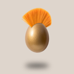 Golden Easter egg with mohawk hair. Minimal concept.