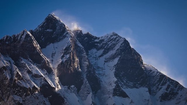 The timelaps of the mountain top in the snow against the sky. Andreev.