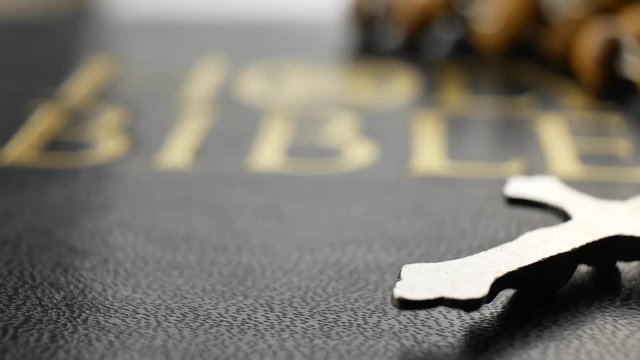 Holy bible and cross on a wooden chain are turning