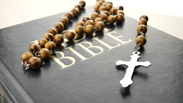 Holy bible and the cross on wooden chain are turning