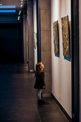 A little cute girl standing in the gallery