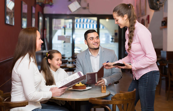 waitress taking table order at cafe