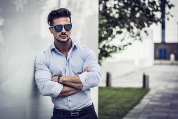 One handsome elegant young man in urban setting in European city, standing