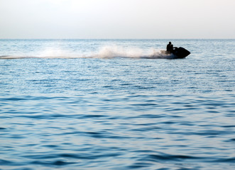 Silhouettes of people in motion on jetski