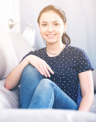 Obraz premium Girl with smile sitting on couch