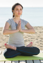 Fototapeta na wymiar Girl doing cross-legged yoga pose
