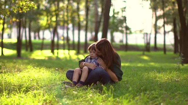 young boy sneezing in the park