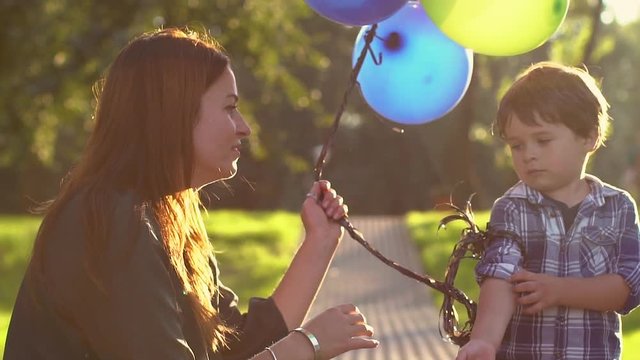 boy with balloons with his mother