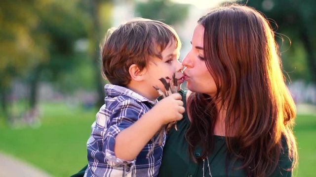 Mom and her son kissing.