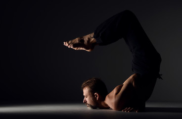 Man practicing yoga scorpion asana pose 