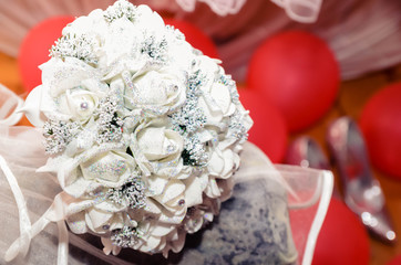 Wedding big bouquet of white rose for bride. in the background is bride shoes and red balloons