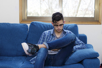 Obraz premium young man in the home sofa with mobile phone