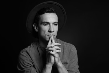 Serious young man on dark background, black and white effect