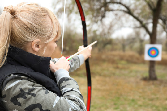 Woman practicing archery outdoors
