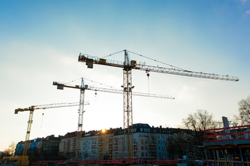 Berlin, Germany - 01 14 2018: Construction Site with Cranes in Backlight with Sun over Buildings