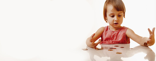 Teaching kid Business. Start financial education of cute little child girl with coins. Wealth, money, cash, success, kids financial literacy concept. © zwiebackesser