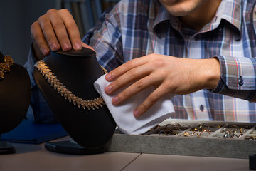 Young male jeweller working at night in his workshop