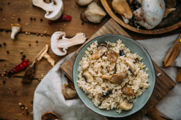 Risotto with mushrooms on an old wooden background. Rustic style.
