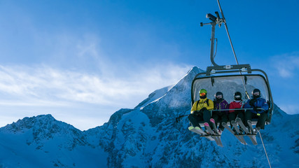 Ski holiday - family of skiers on chairlift in high Alpine ski resort