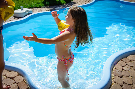 Little fun girl is swimming pool