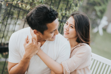Happy Asian couple in love smiling and having fun while hugging outdoor.