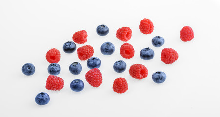 Raspberries and blueberries on white background.  top view