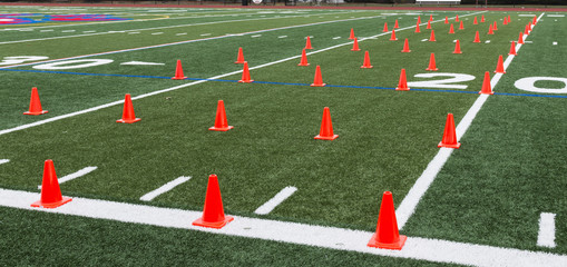 Turf field set up with orange cones for agility exercises
