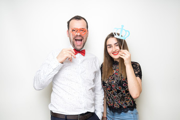 young couple friends pose photo booth funny props