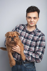 Closeup portrait handsome young hipster man, kissing his good friend red dog isolated light background. Positive human emotions, facial expression, feelings