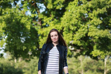 Young girl on a walk. Girl in a leather jacket on the street. Be