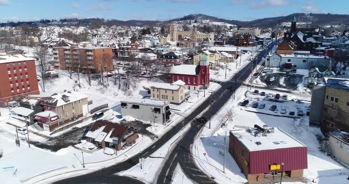 A slow forward winter aerial shot of traffic patterns in the business district of Rochester, PA, a Pittsburgh suburb.  	