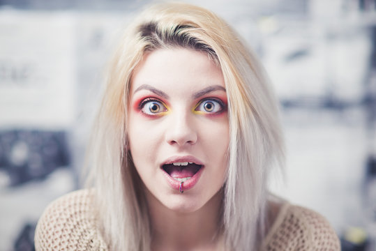 Blond young woman shocked expression red makeup
