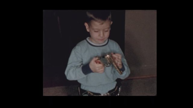 1956 Young boy shoots toy gun and shows off skills