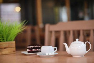 Kettle with a drink and dessert in a street cafe. Tea in the ket