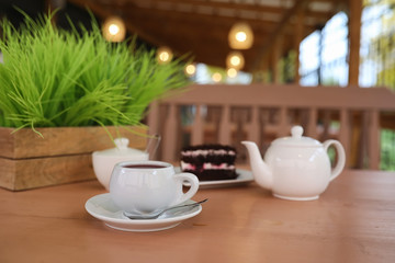 Kettle with a drink and dessert in a street cafe. Tea in the ket