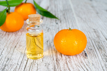 tangerine natural oil in bottle on white wooden rustic table