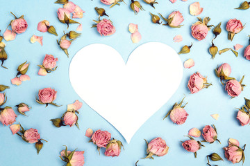 Blank heart-card with small pink roses on blue background. Place for text.