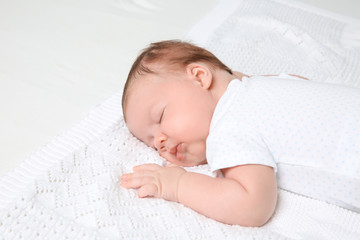 Cute newborn baby sleeping on soft blanket