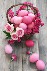 Obraz na płótnie Canvas Varicolored pink Easter eggs in wicker basket